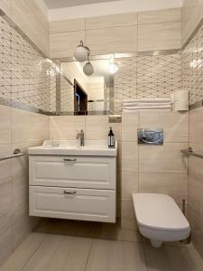 W łazience znajduje się umywalka, toaleta i lustro. w obiekcie SPOT JURATA w Juracie