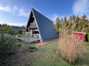 uma pequena casa com um telhado preto num quintal em Ostseeferienhaus Finni em Ribnitz-Damgarten