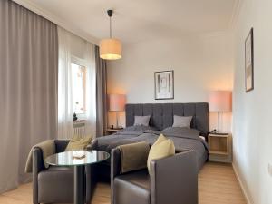 ein Schlafzimmer mit einem Bett, einem Tisch und einem Sofa in der Unterkunft AhrPart Hotel Central in Bad Neuenahr-Ahrweiler