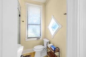 uma casa de banho com um WC branco e uma janela em Aerie Loft em Biloxi