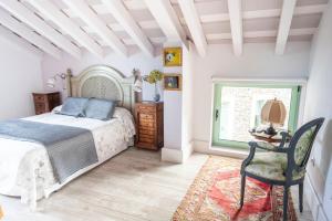 a bedroom with a bed and a chair and a window at Posada Rolisas in Polanco