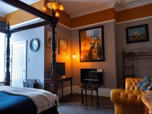 スカーバラにあるAshburton House - B&Bのベッドルーム1室(ベッド1台、テレビ、ベッド1台、ソファ付)