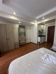 a large bedroom with a white bed and a kitchen at Birinci Apart Hotel in Istanbul