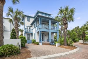 a blue house with palm trees in front of it at My Blue Heaven in Rosemary Beach