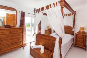 um quarto com uma cama de dossel e uma cómoda em Can Ramos em Ses Fontanelles