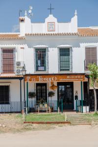 een wit gebouw met een restaurant ervoor bij El traslado alojamiento rural in El Rocío