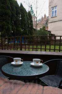 two coffee cups sitting on a table on a patio at Podzamcze - near Wawel and Old Town in Krakow