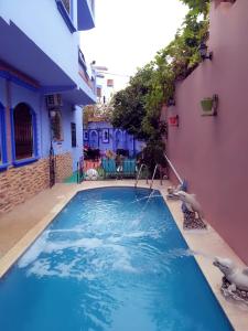 una piscina de agua azul en un edificio en villa Rita chaouen, en Chefchaouen