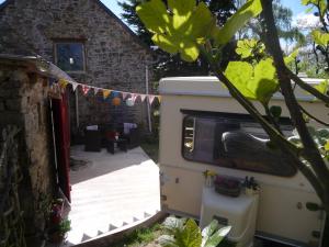 ein Wohnmobil auf einem Hof mit Terrasse in der Unterkunft B&B Chambre d'hôtes et Glamping, Bretagne mer et campagne Brittany sea and countryside in Pleumeur-Gautier