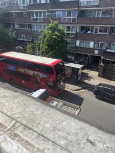 un autobús rojo estacionado en una calle frente a un edificio en Charming 1-Bed Apartment in London, en Londres