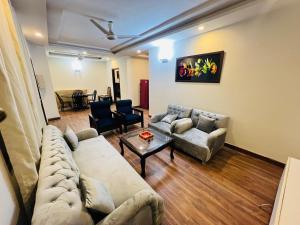 ein Wohnzimmer mit 2 Sofas und einem Tisch in der Unterkunft Luxe and Family-friendly 2BHK in Islamabad