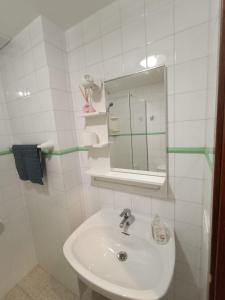 ein weißes Badezimmer mit Waschbecken und Spiegel in der Unterkunft Apartamento SUNNY Complex Amaya Fuerteventura in Costa de Antigua