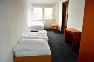 2 camas en una habitación pequeña con ventana en Lotos, en Karlovy Vary