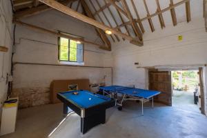 2 mesas de ping pong en una habitación con ventana en The Tallet at Accott Manor, 