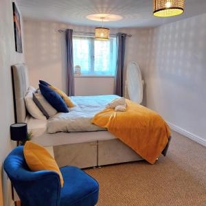 Stylish Bungalow in Symonds Yat في هيريفورد: غرفة نوم بسرير وكرسي ازرق