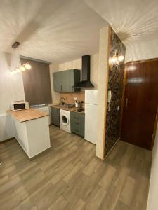 a kitchen with white appliances and a wooden floor at Moncloa Urban Apartment in Madrid