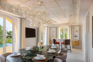 a dining room with a table and chairs and a chandelier at Grand-Hôtel du Cap-Ferrat, A Four Seasons Hotel in Saint-Jean-Cap-Ferrat