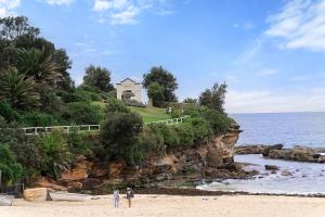 a house on top of a cliff next to the ocean at THE SHORE (1): COOGEE BEACH in Sydney