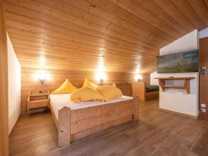 ein Schlafzimmer mit einem Bett in einem Holzzimmer in der Unterkunft Apartment in Neustift with a ski storage in Neustift im Stubaital