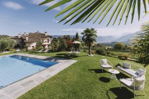 a backyard with a swimming pool and a lawn with chairs at Weinberghof in Appiano sulla Strada del Vino