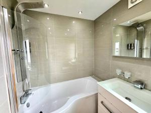 y baño con bañera blanca y lavamanos. en 3 Bed House with 6 Beds by Sensational Stay en Edimburgo
