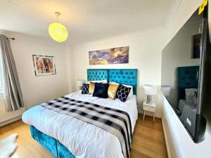 Schlafzimmer mit einem großen Bett mit blauem Kopfteil in der Unterkunft 3 Bed House with 6 Beds by Sensational Stay in Edinburgh