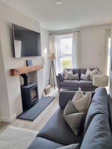 uma sala de estar com um sofá e uma lareira em New to 2024 Cosy Beach Home em Castlerock