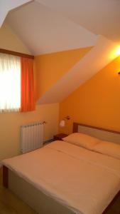 a bedroom with a bed and a window at Pansion Rody in Gornja Stubica