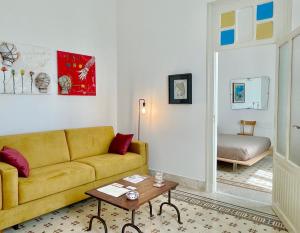 uma sala de estar com um sofá e uma mesa em DOMUS ALERIA Deluxe Rooms em Sciacca
