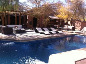 a swimming pool with lounge chairs and a swimming pool at Hotel La Aldea in San Pedro de Atacama