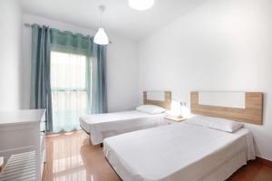 a hotel room with two beds and a window at Casa Rosi 1 in Puerto del Rosario