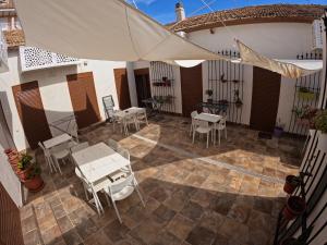 patio ze stołami, krzesłami i parasolem w obiekcie Apartamentos La Encarnación III w mieście Los Alcázares