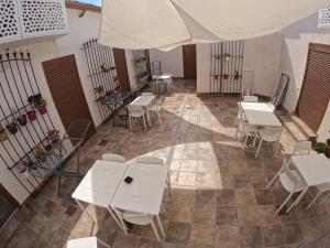 puste patio ze stołami, krzesłami i parasolem w obiekcie Apartamentos La Encarnación III w mieście Los Alcázares
