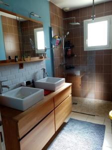 a bathroom with two sinks and a shower at Le chêne blanc in La Genétouze