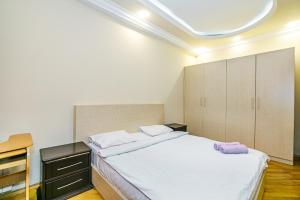 a bedroom with a large white bed and cabinets at Boulvard M Estate in Baku