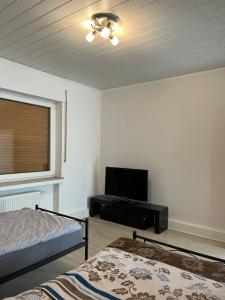 Monteurewohnung L770 في Stemwede: غرفة نوم بسرير وتلفزيون بشاشة مسطحة