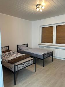 2 camas en una habitación con ventana en Monteurewohnung L770 en Stemwede