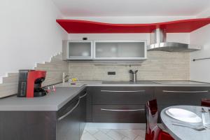 d'une cuisine avec des appareils en acier inoxydable et un plafond rouge. dans l'établissement Ca' Balin - Chioggia, à Chioggia