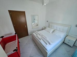 a bedroom with a bed and a mirror and a door at Villa A & A in Ksamil