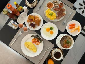 a table with plates of breakfast food on it at Mintra Hotel in Vientiane