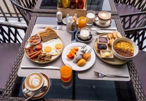 a breakfast table with breakfast foods and coffees and coffee at Mintra Hotel in Vientiane