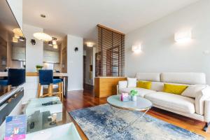 ein Wohnzimmer mit einem Sofa und einem Tisch in der Unterkunft VacationClub–Sea Towers Apartament 73 in Gdynia