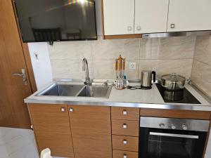 a kitchen with a sink and a stove at Villa A & A in Ksamil