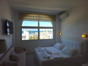 a bedroom with a bed and a large window at Villa A & A in Ksamil