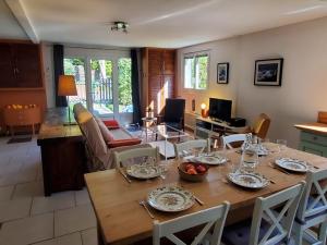 a dining room and living room with a table and chairs at Au Petit Sequoia - Appt avec vue montagne in Saint-Mamet