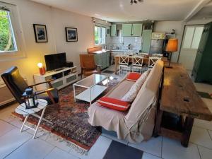 a living room with a couch and a table at Au Petit Sequoia - Appt avec vue montagne in Saint-Mamet