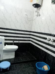 Hotel maa janki palace ayodhya في Ayodhya: حمام اسود وبيض مع مرحاض ومغسلة