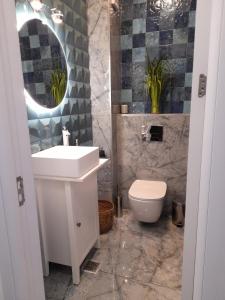 a bathroom with a sink and a toilet and a mirror at Apartament Palma 2 Stefan Resort in Mamaia Sat/Năvodari
