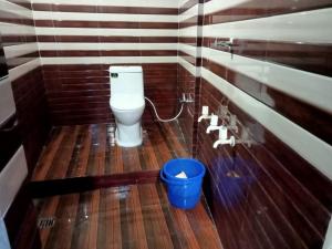 a bathroom with a toilet and a blue bucket at Hotel maa janki palace ayodhya in Ayodhya