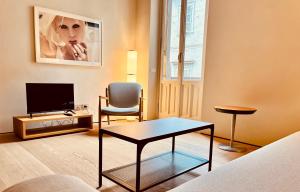 a living room with a tv and a table and a chair at Zerbion Collection - Palazzina Scotti in Piacenza